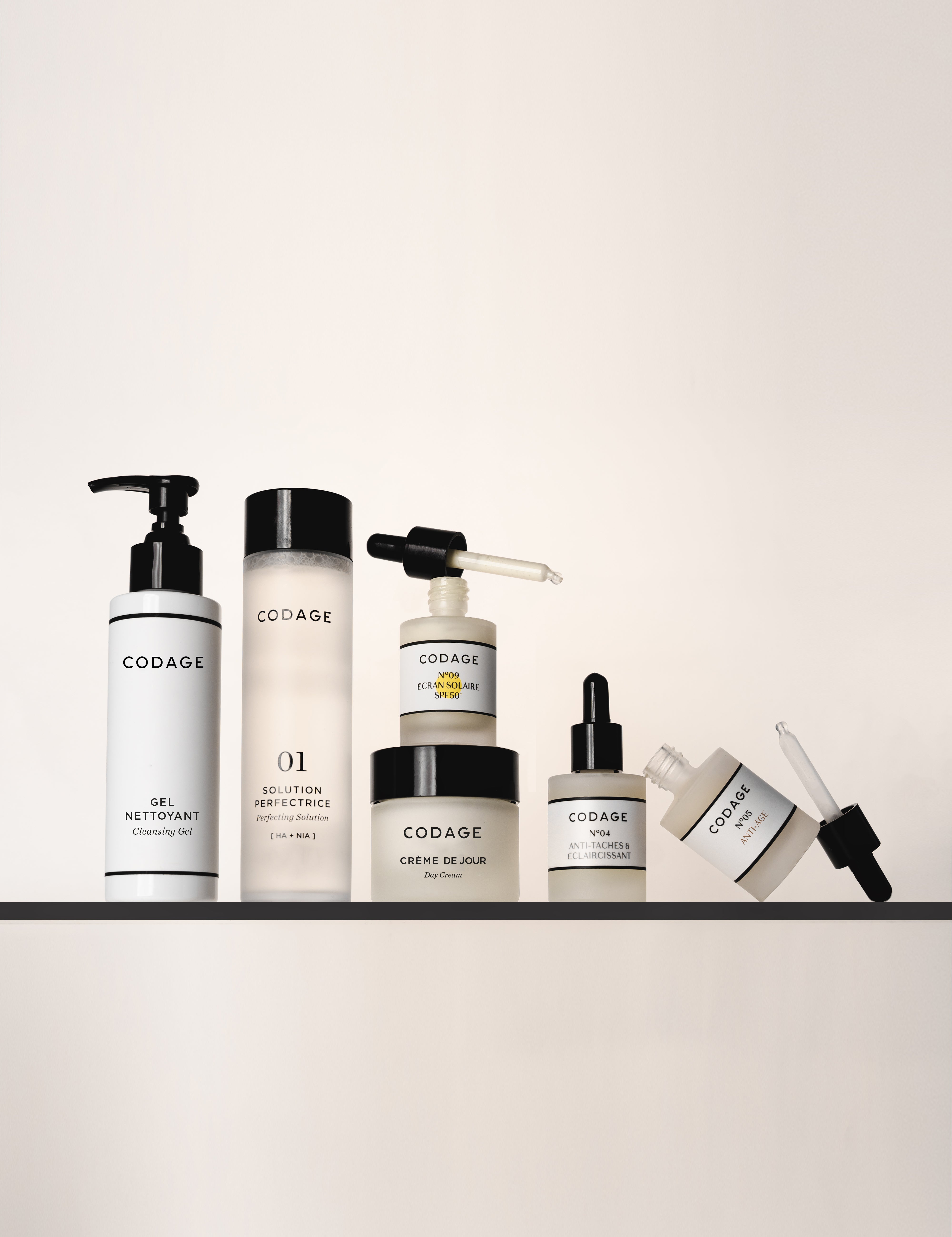 Collection of Codage skincare products on a white shelf with a white background