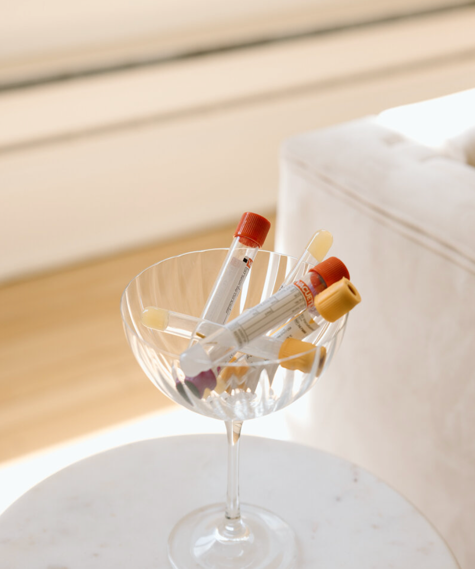 Clear glass with colorful markers on a white surface