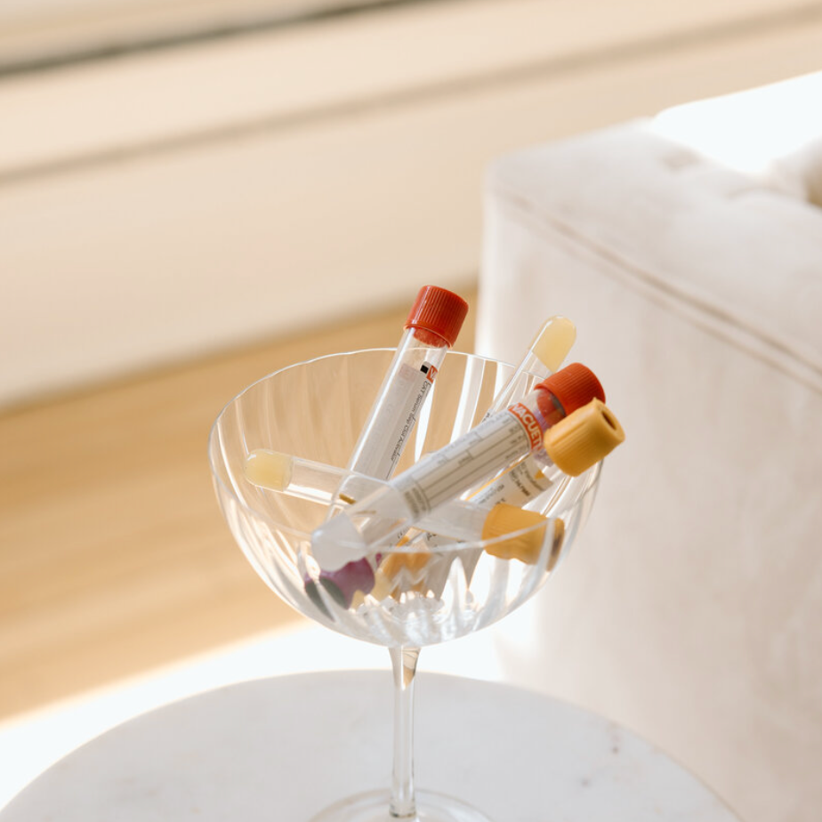 Clear glass with colorful markers on a white surface