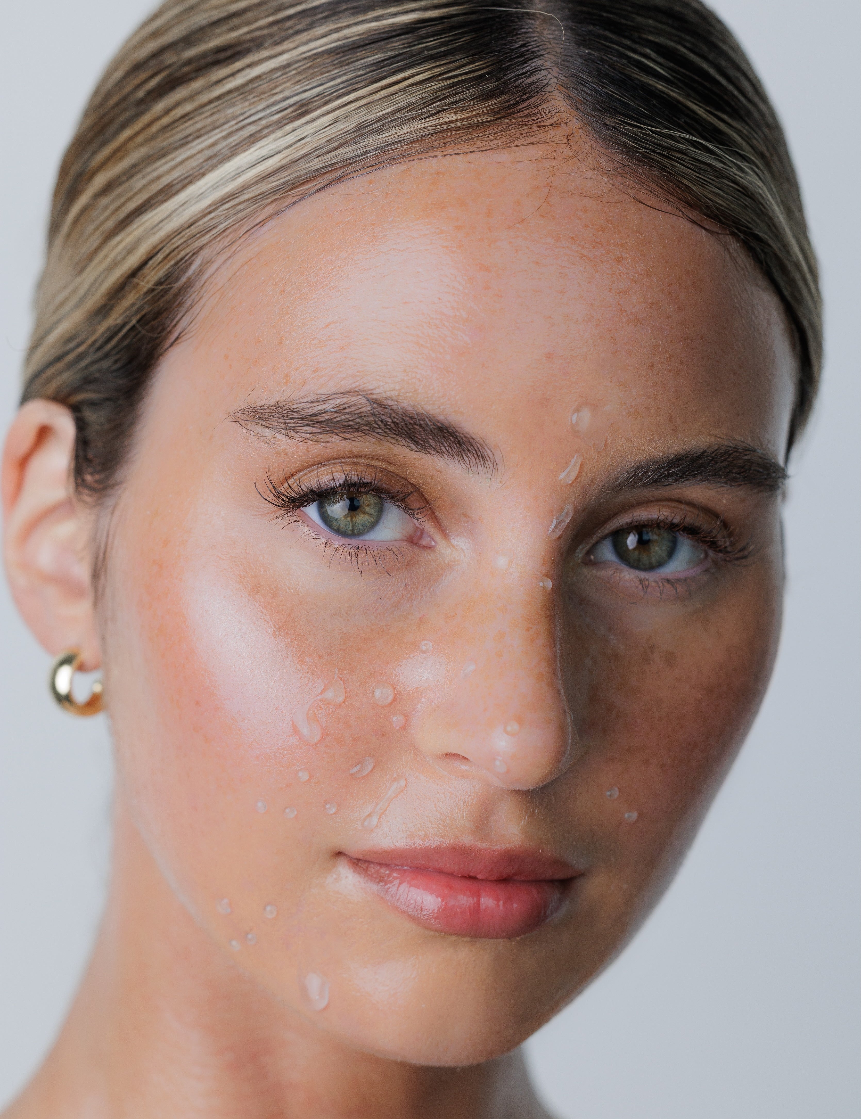 image of a womans face with wet drops on it.