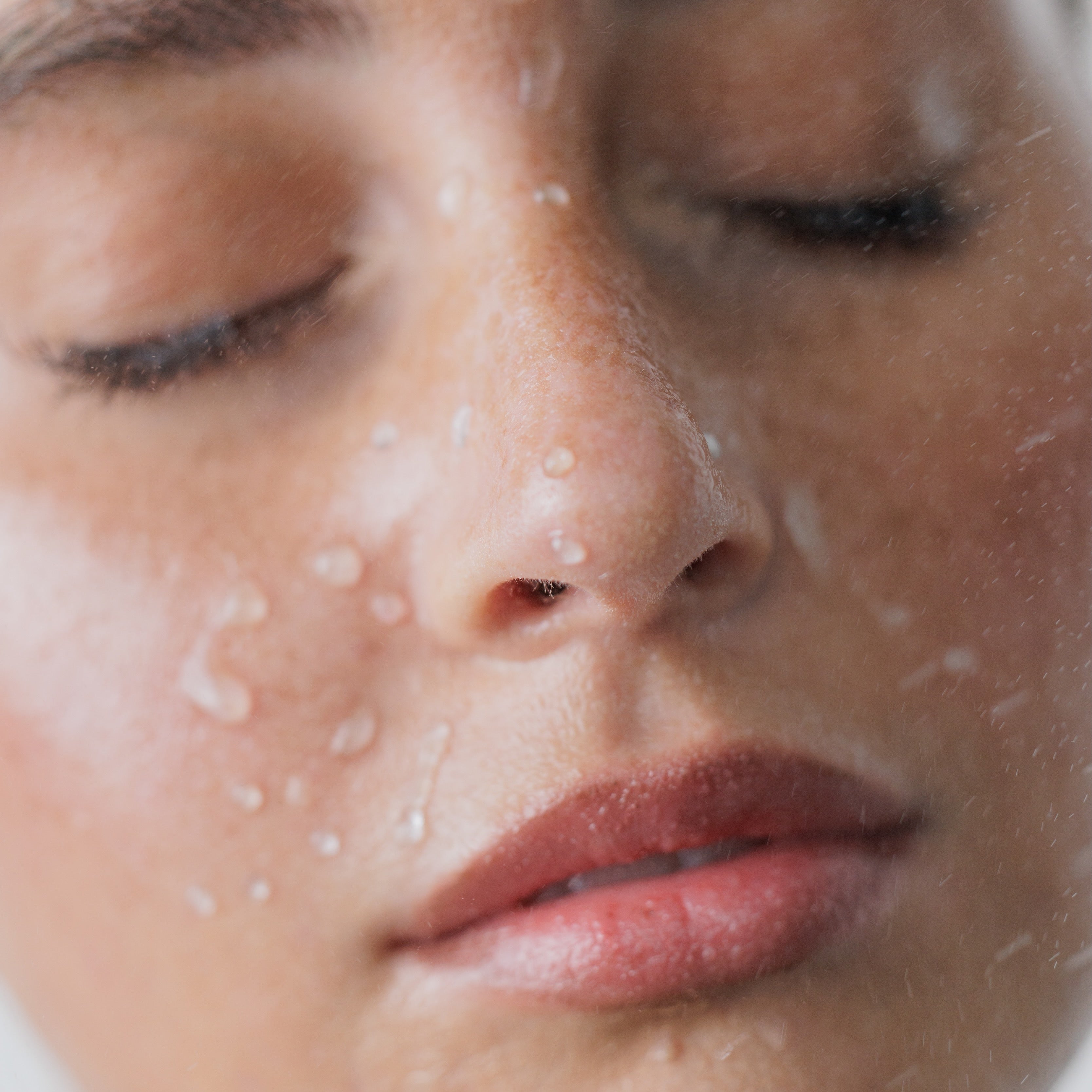 Close-up of a woman's face with water droplets on her skin