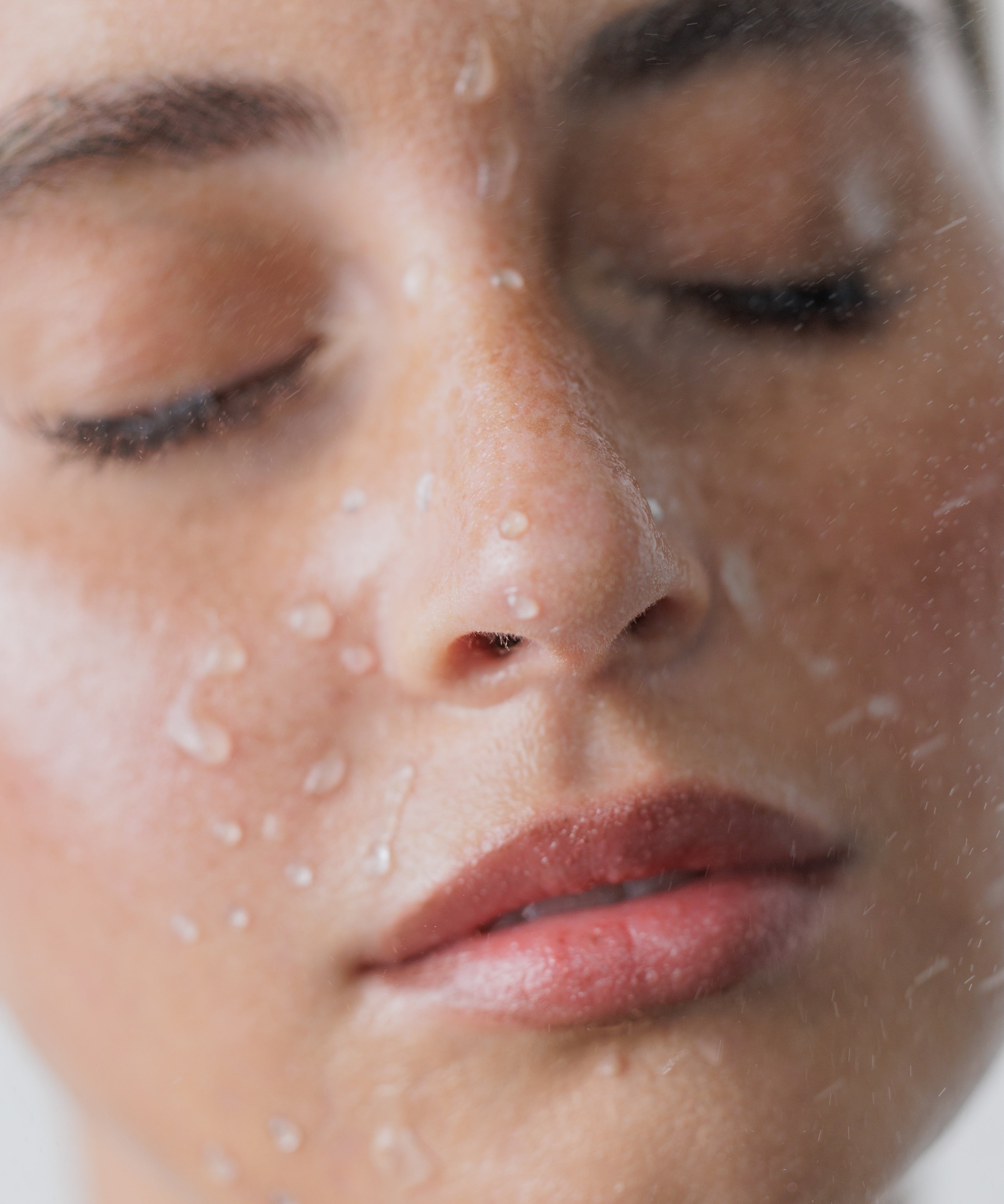 Close-up of a woman's face with water droplets on her skin